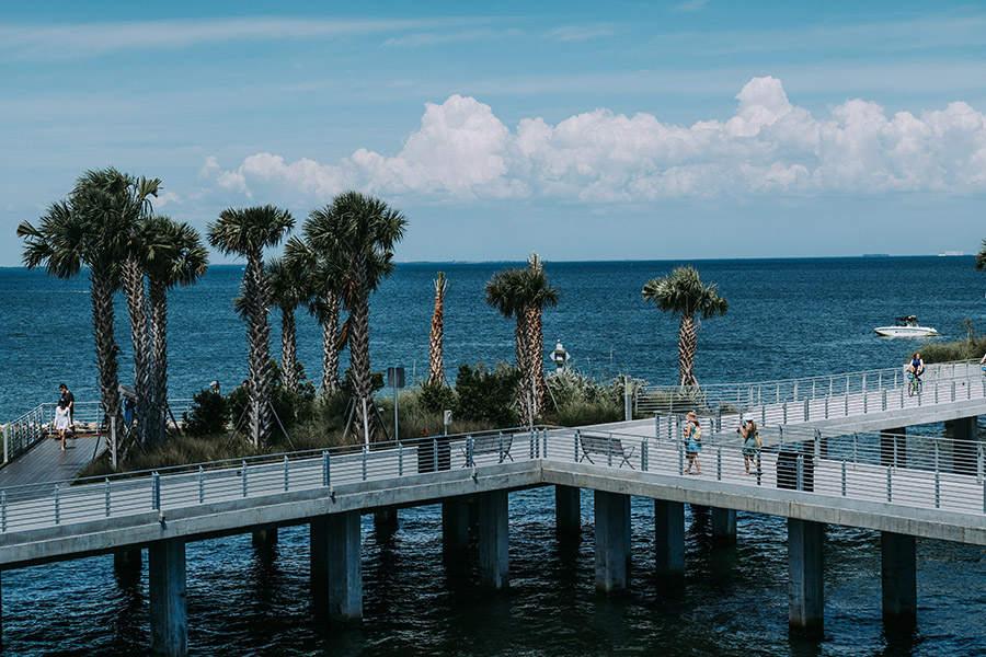 Saint Pete pier with lush palm trees and people walking.